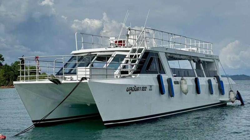 Двухкорпусный катамаран Blue Anda 122 с верхней палубой на якоре у берега