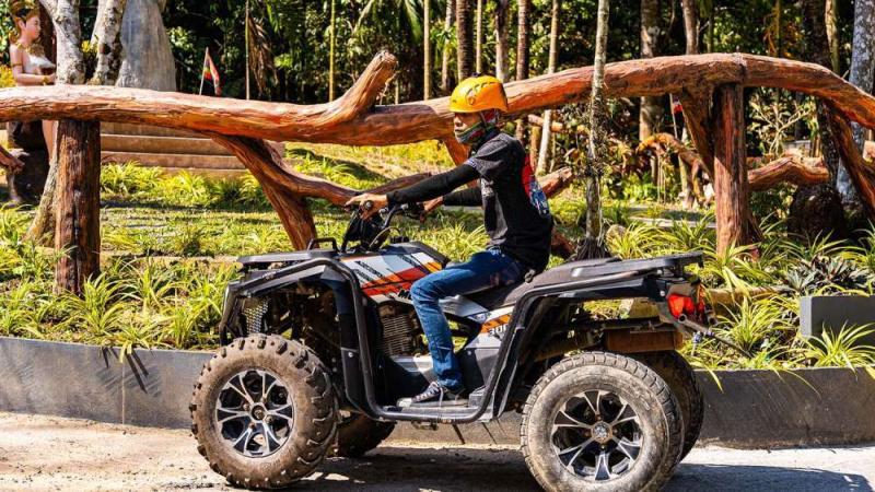 Гость в шлеме на квадроцикле у деревянной ограды на старте трассы Patong Mountain View