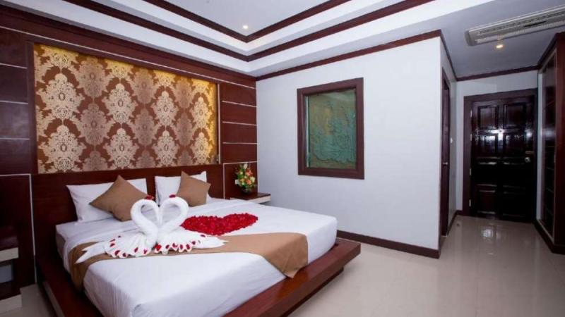 Номер отеля Andaman Beach Resort: большая кровать, узорное панно и лебеди из полотенец