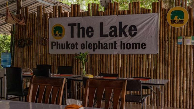 Столовая The Lake Phuket Elephant Home: столы у бамбуковой стены с вывеской