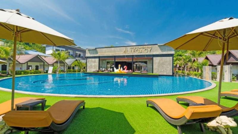Бассейн отеля Legacy на Пхи-Пхи Дон: шезлонги, зонты и корпус с вывеской