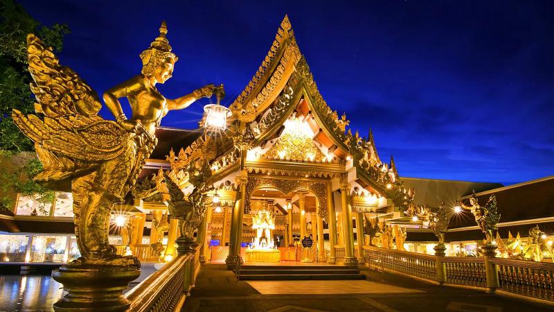 Золотая статуя киннари у ресторана Golden Kinnaree в парке Phuket FantaSea вечером