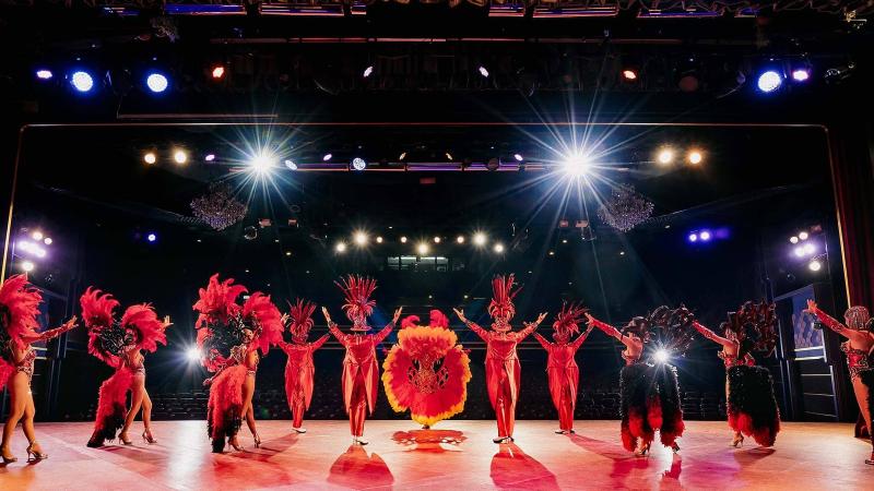 Сцена Simon Cabaret в Патонге: труппа в красных костюмах с перьями выстроилась в линию под софитами