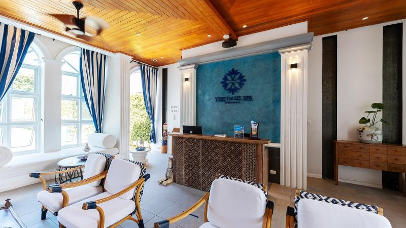 Ресепшен салона Oasis Turquoise Cove: белые кресла, арочные окна и сине-белые шторы