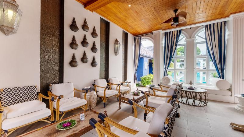 Лаунж салона Turquoise Cove с белыми креслами, деревянным потолком и арочными окнами