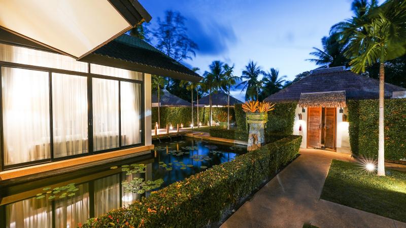Виллы салона Tropical Retreat у пруда с подсветкой, над ними пальмы Лагуны