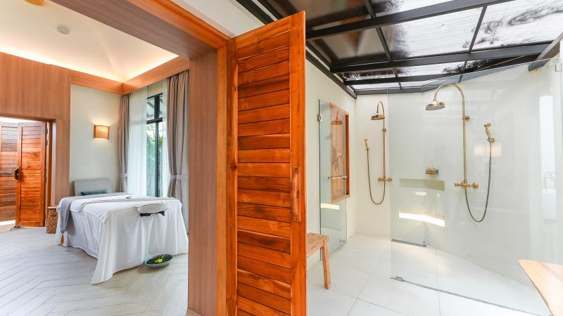 Вилла салона Tropical Retreat: массажный стол и душ под стеклянной крышей