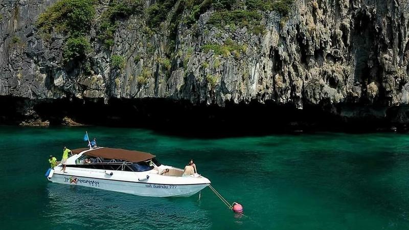 Катер JP Andaman на якоре у отвесной известняковой скалы, бирюзовая вода