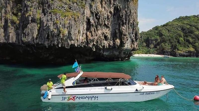 Катер JP Andaman у скалы, на носу и корме — пассажиры и команда