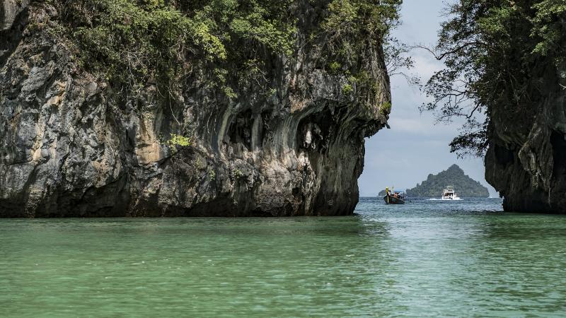 Вход в лагуну острова Хонг в Краби: скалы над зелёной водой и лодка в проходе