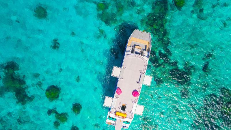 Двухпалубный катамаран SeaStar сверху: открытая верхняя палуба над коралловым рифом