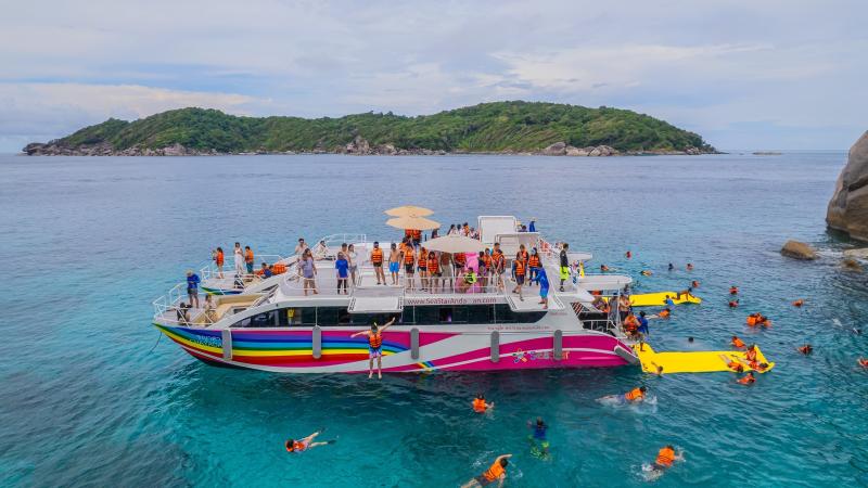 Двухпалубный катамаран SeaStar у острова, вокруг гости плавают с масками