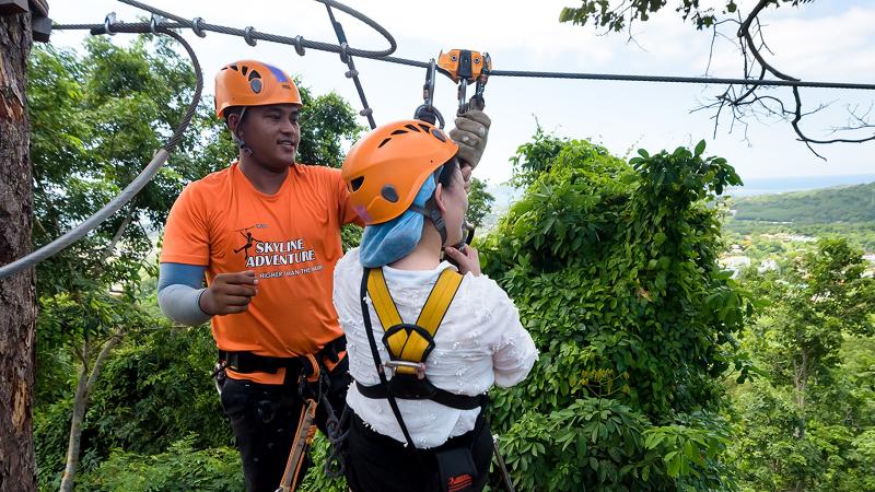 Гид Skyline Adventure проверяет снаряжение гостьи перед спуском по тросу