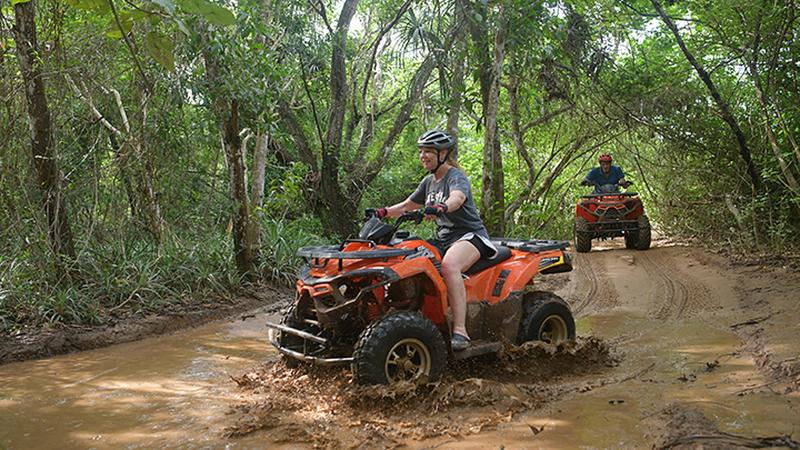 Квадроцикл проезжает лужу на лесной трассе Phuket ATV Tour в Таланге