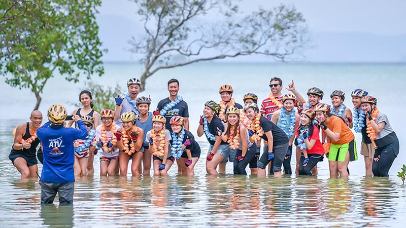 Гости Phuket ATV Tour фотографируются в воде у скрытого пляжа за мангровым лесом