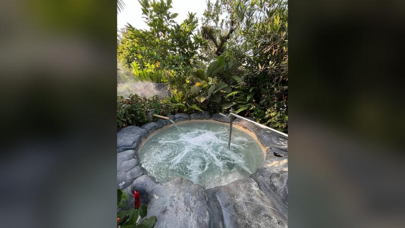 Круглый каменный бассейн с бурлящей водой и паром в Mantra Forest Spa