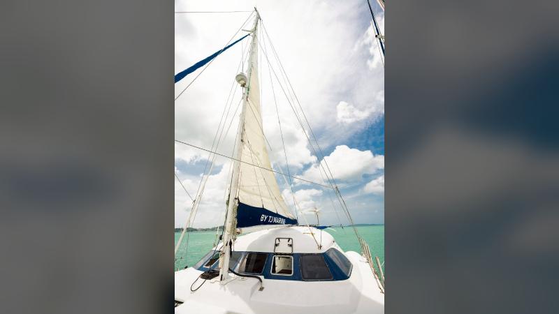 Парус и рубка катамарана под облачным небом — на этой лодке можно идти под парусами