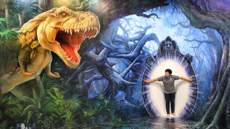 Посетитель перед нарисованным динозавром и фантастическим лесом в 3D-галерее