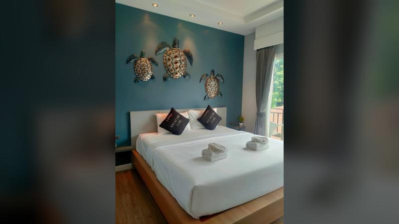 Номер отеля Andaman Beach Resort: двуспальная кровать и бирюзовая стена с черепахами