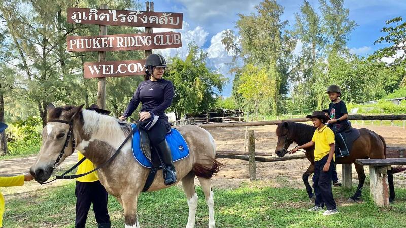 Ворота Phuket Riding Club в Май Кхао: всадников на лошадях ведут инструкторы клуба