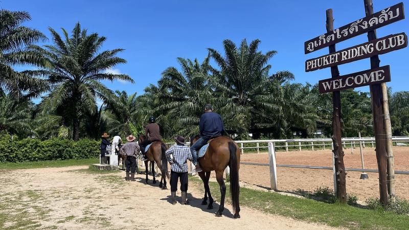 Всадники с инструкторами отправляются на прогулку от ворот Phuket Riding Club, справа — манеж
