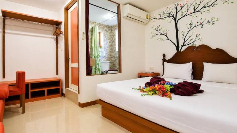 Номер в отеле Phi Phi Arboreal Resort на Пхи-Пхи Дон: двуспальная кровать и роспись с деревом на стене