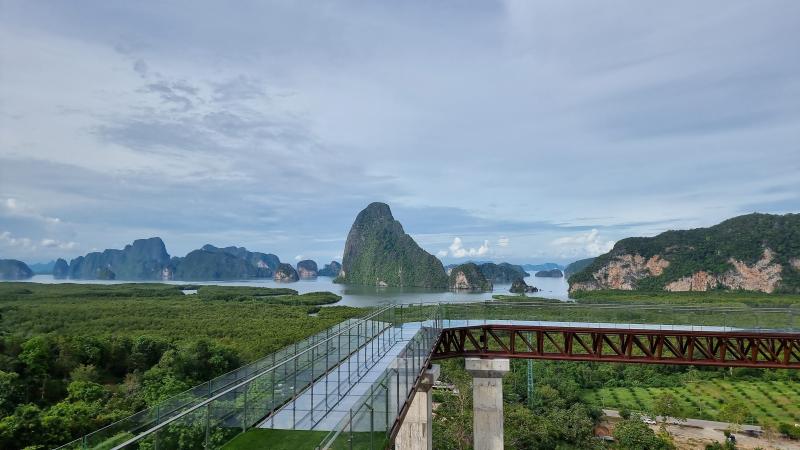 Стеклянный мост Beyond Skywalk на Самет Нангше днём над лесом, вдали скалы залива Пханг Нга