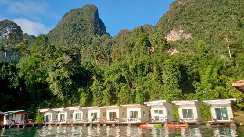 Ряд бунгало Saichol Raft House у подножия известняковой скалы на озере Чео Лан