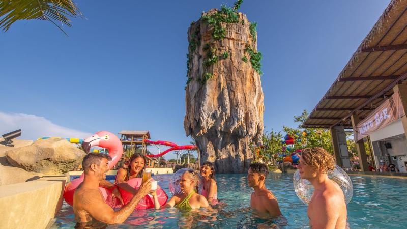 Гости с надувными кругами у бара Wave Bar в бассейне под скалой Ко Тапу — аквапарк Андаманда