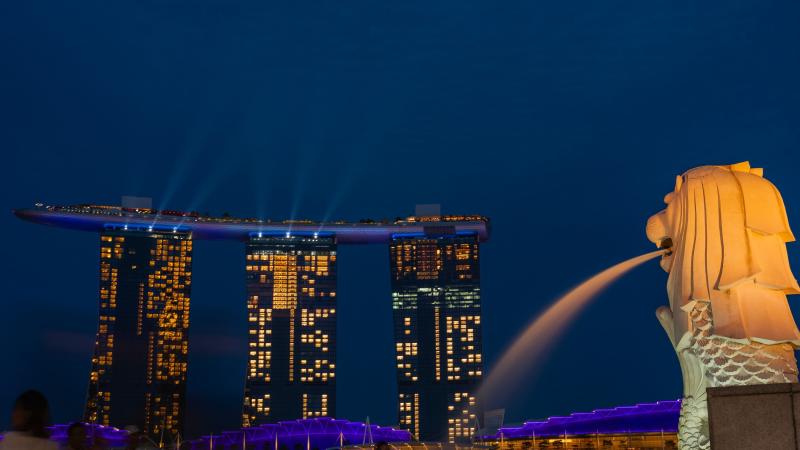 Статуя Мерлиона у залива Марина-Бэй и отель Marina Bay Sands вечером — Сингапур