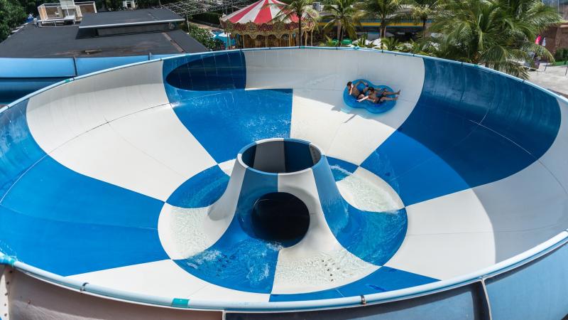 Горка-воронка Super Bowl в аквапарке Splash Jungle на Пхукете: гость на круге скатывается по бело-синей чаше