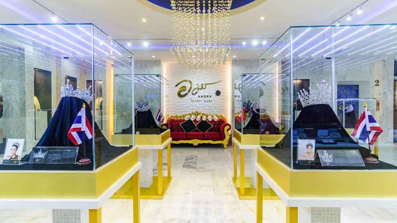 Витрины с коронами в зале Amorn магазина Phuket Pearl на Пхукете, рядом тайские флаги