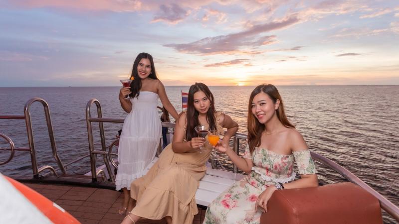 Три подруги с коктейлями на корме лодки Melody, солнце садится в море