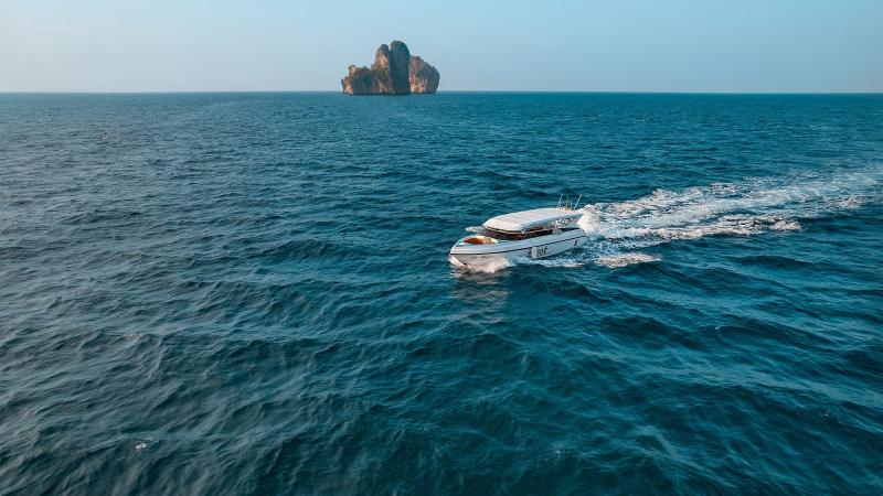 Катер Best на ходу в открытом море, впереди — скалистый остров